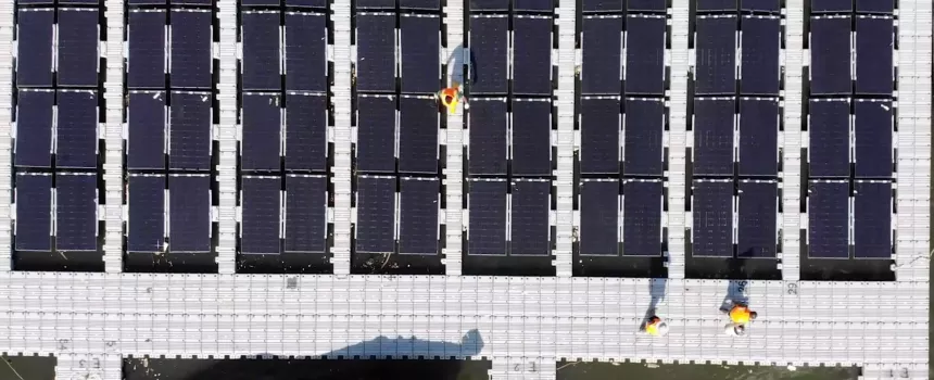 In the image we see a person crossing an installation of solar panels.